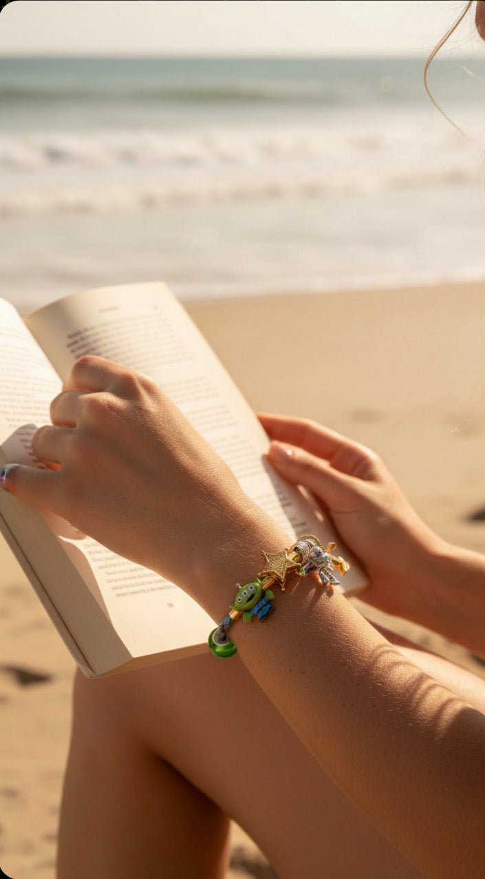 Mujer en la playa leyendo un libro con una pulsera Belléa Toy Story